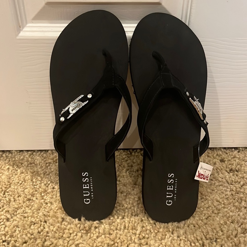 Guess black flip flops w/silver embellishment. Size 10. New w/tags